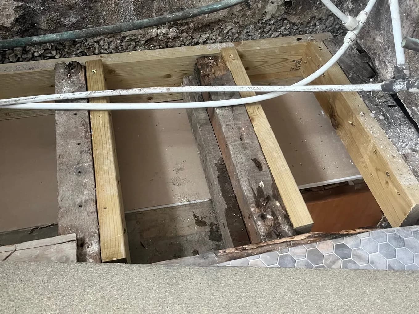 New timbers fitted alongside water-damaged floor joists under a bath during a CLM Projects leak repair in Leeds