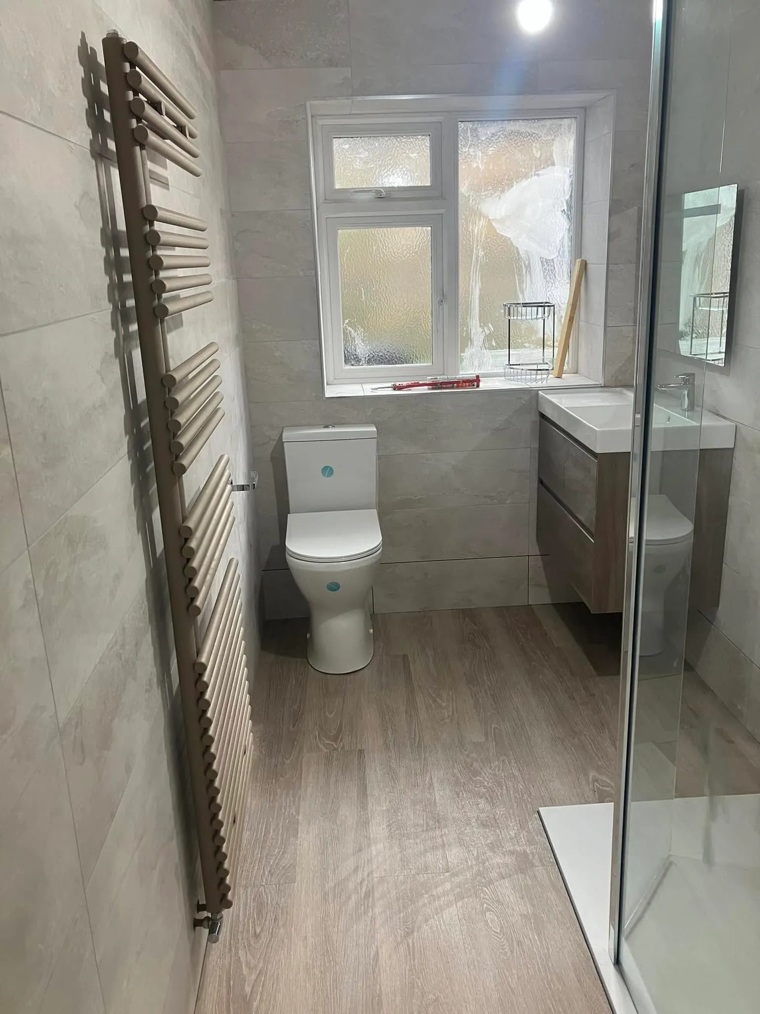 Bathroom with heated towel rail, floating vanity unit and walk-in shower