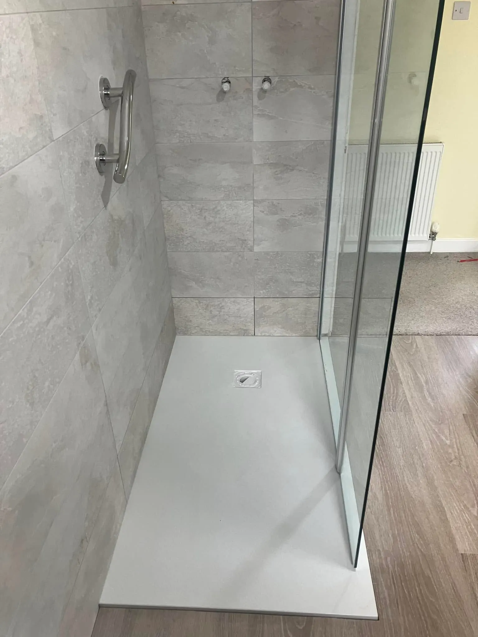Walk-in shower with grey stone-effect tiling and a glass screen