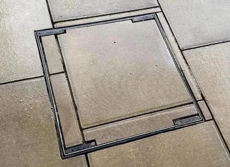 Drain access cover flush-fitted into patio paving