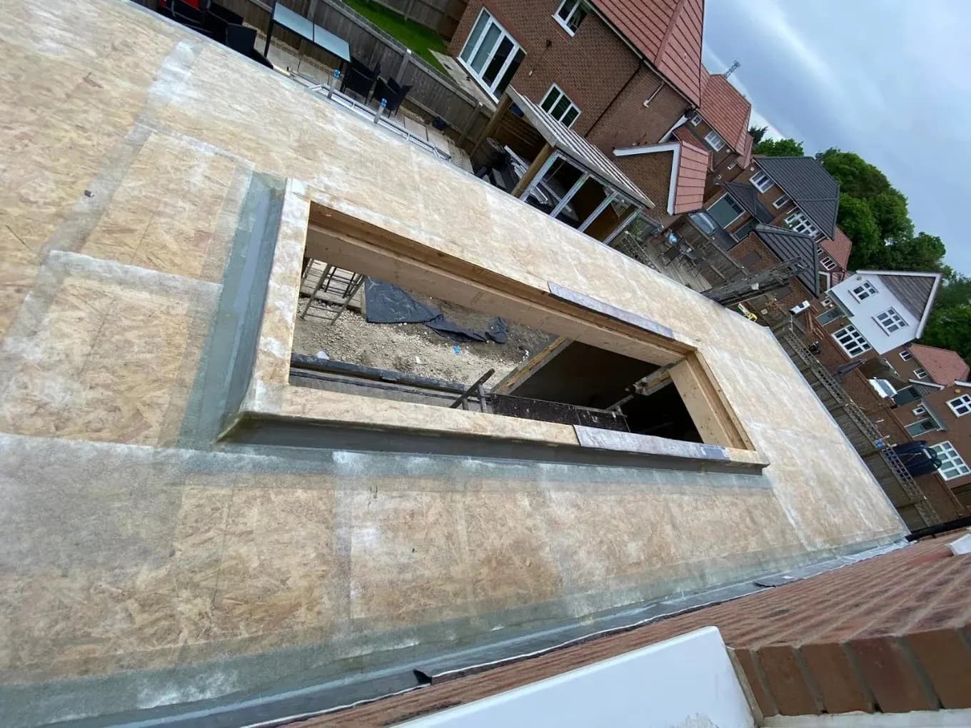 Flat roof deck with a roof window framed