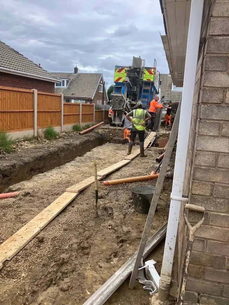 Foundation trench excavation with concrete delivery