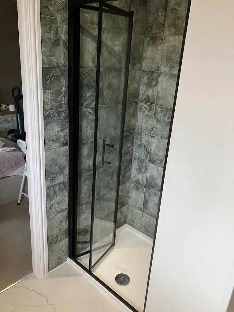 Glass-enclosed shower cubicle with patterned tiles
