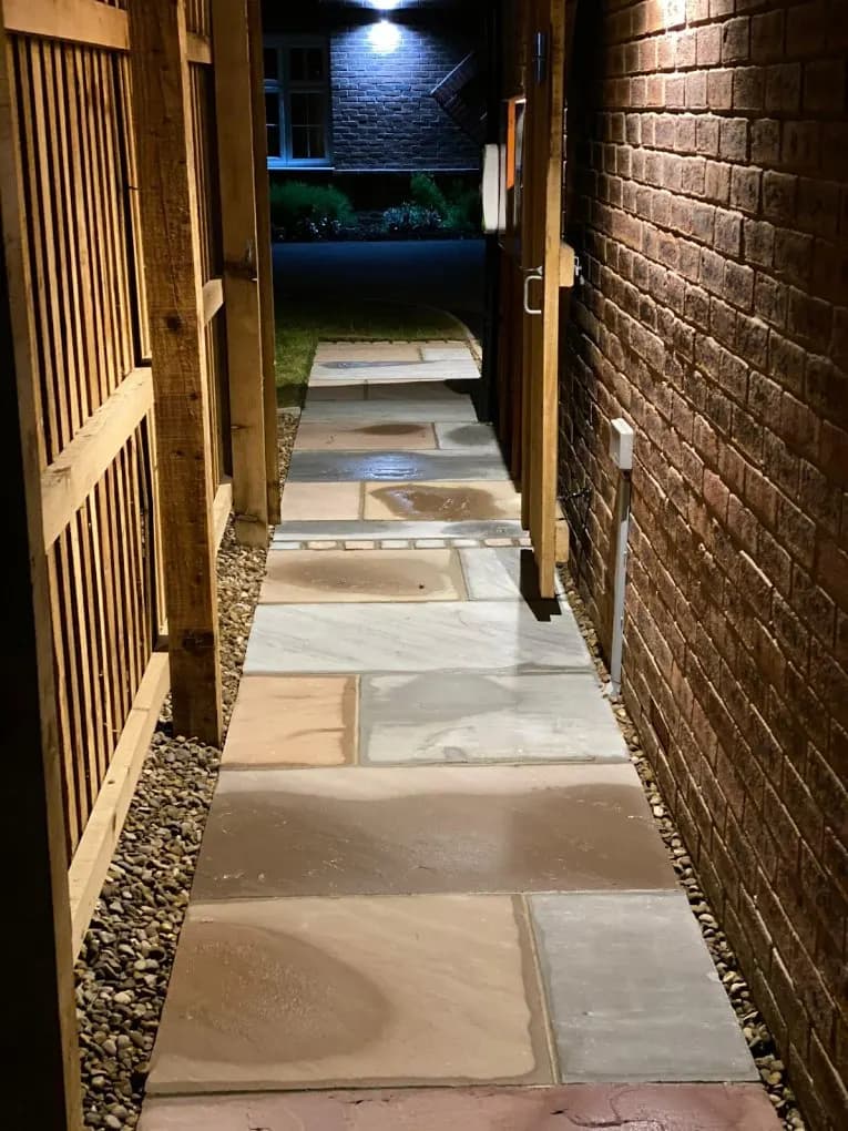 Indian stone pathway lit at night between fences
