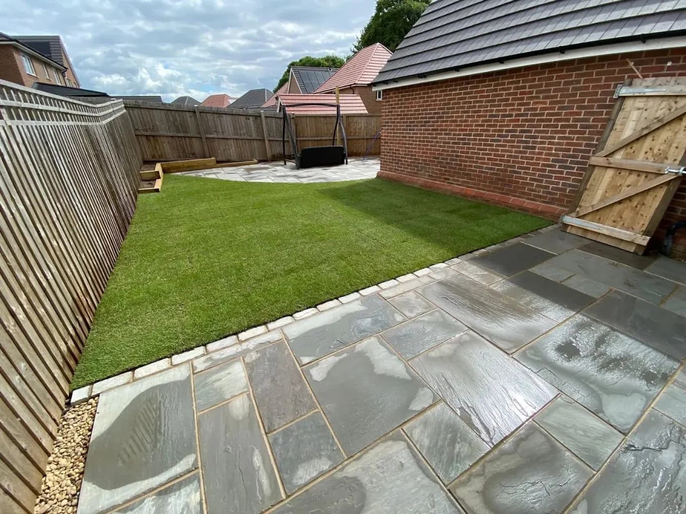 Landscaped rear garden with lawn and paved patio