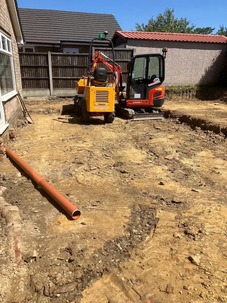 Mini digger preparing groundworks for an extension