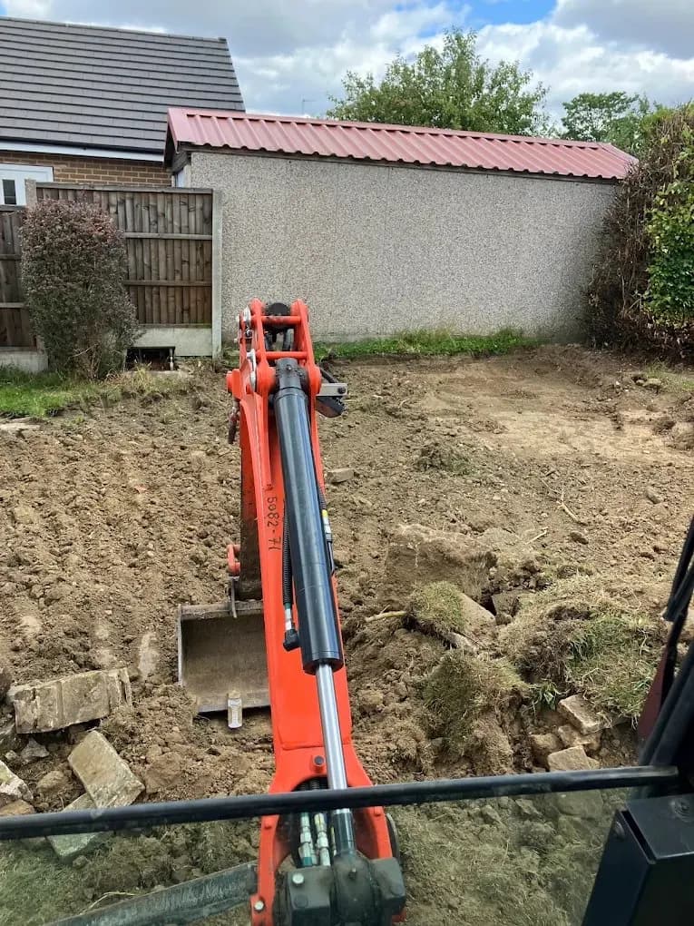 Mini excavator clearing a garden ready for landscaping