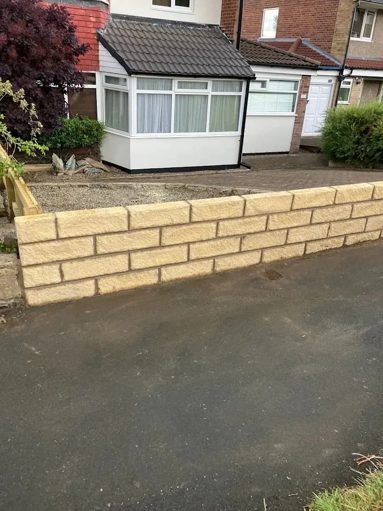 New sandstone garden boundary wall along a driveway