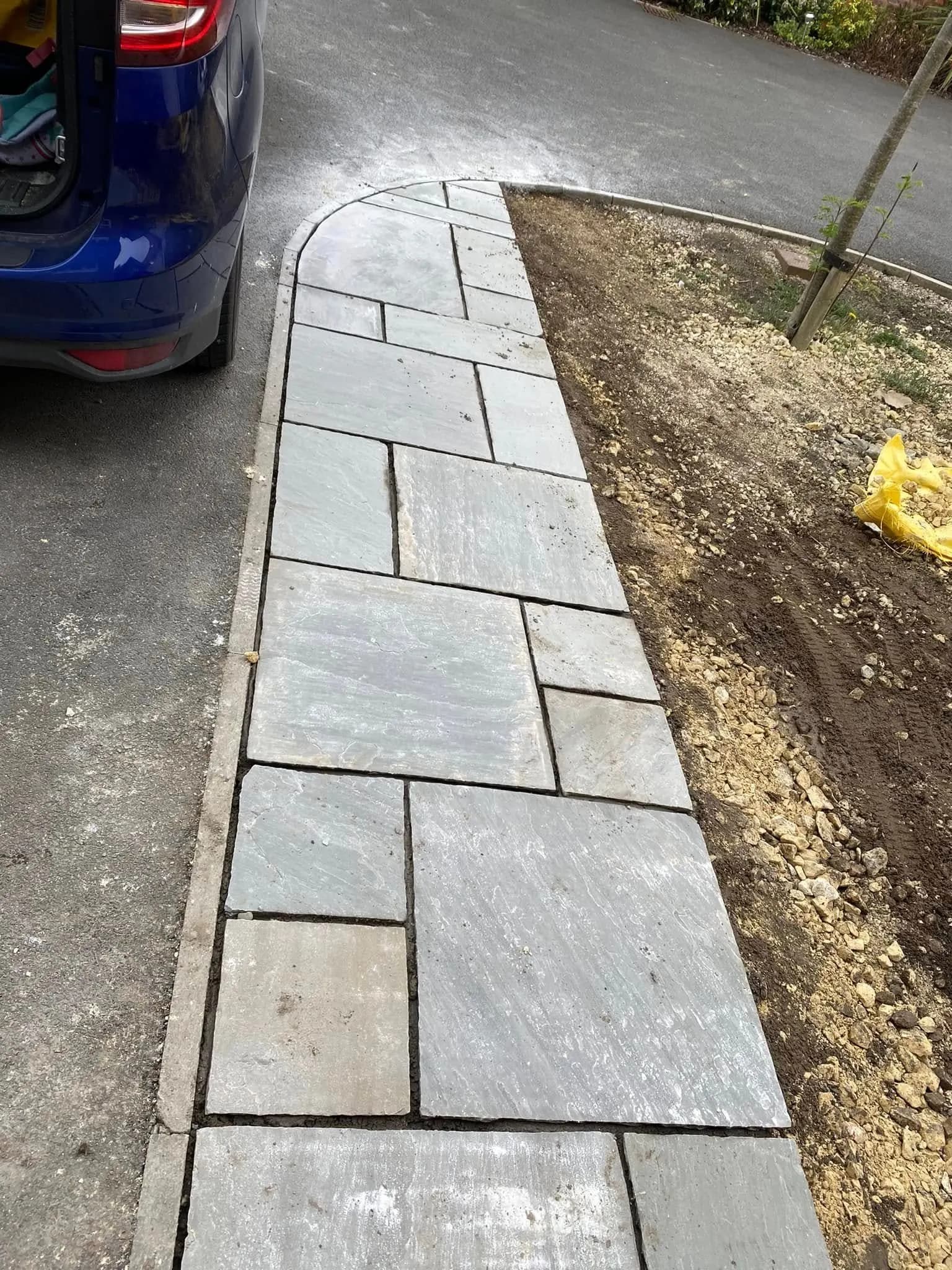 New stone pathway laid alongside a driveway