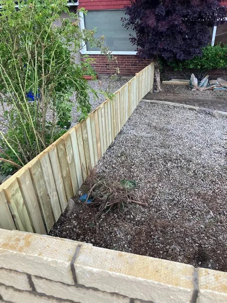 New timber fence panel along a gravel garden path