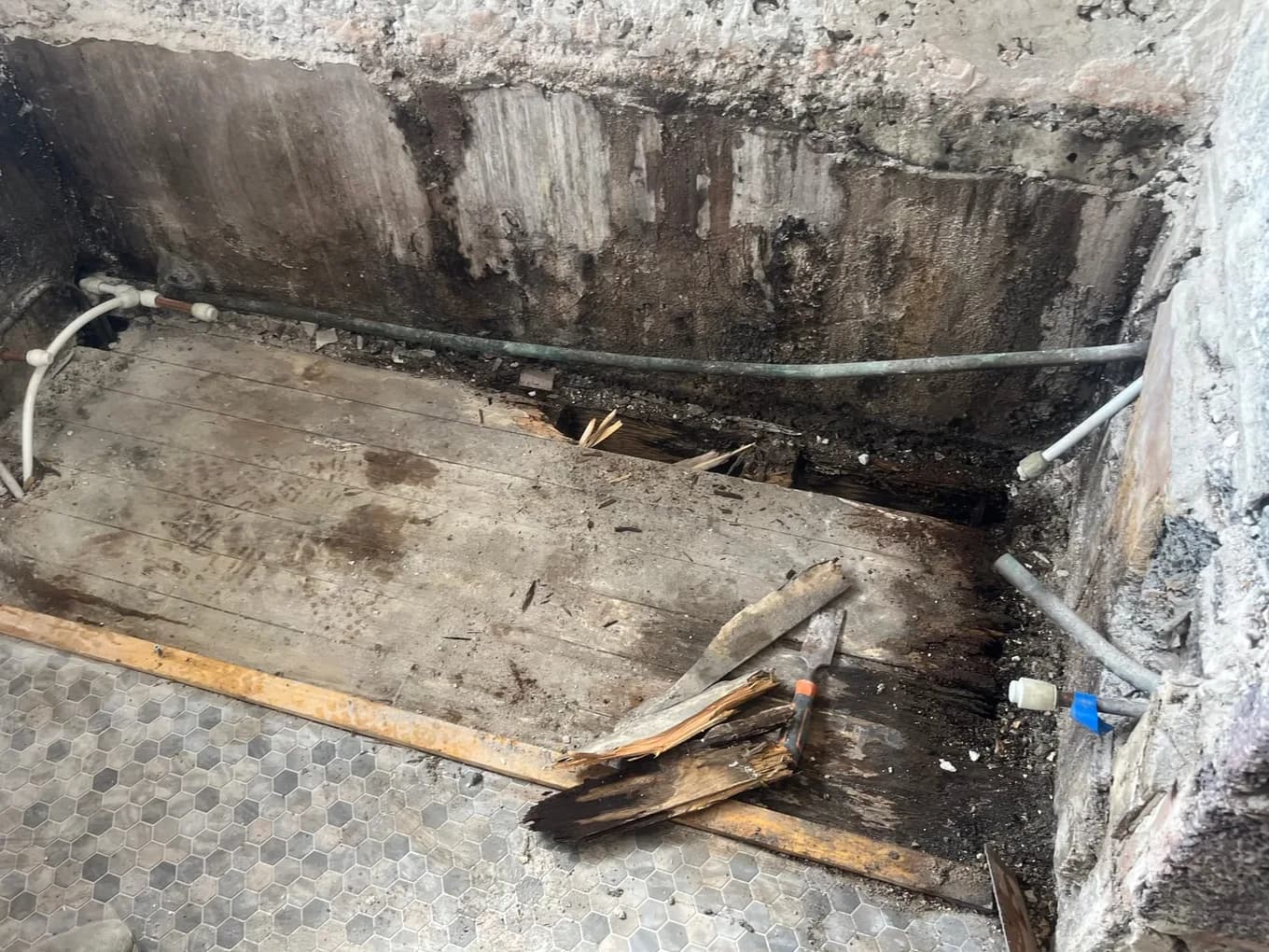 Rotten timber bathroom floor found under a leaking bath during a CLM Projects water damage inspection in Leeds