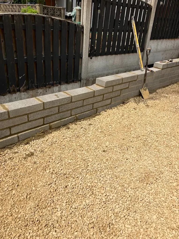 Sandstone block retaining wall with metal fencing