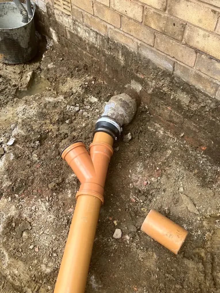 Underground drainage pipe fittings connected at a wall