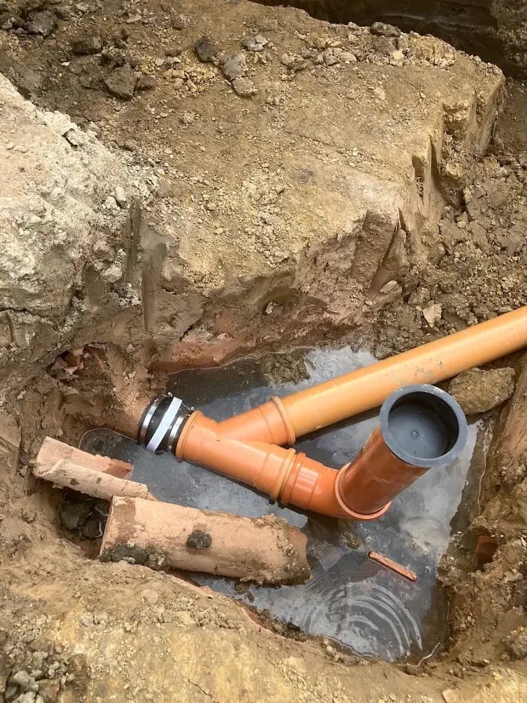 Underground drainage pipe joint in an excavated trench