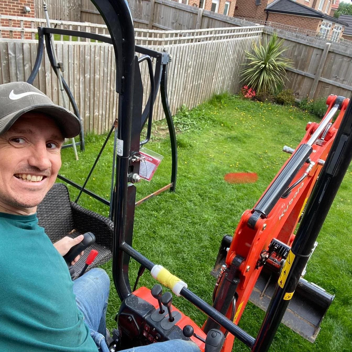 Scott Wilson smiling at the controls of a mini digger on site